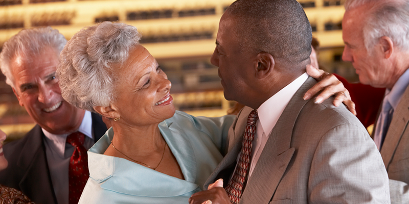 Older black couple dances a slow dance to live music